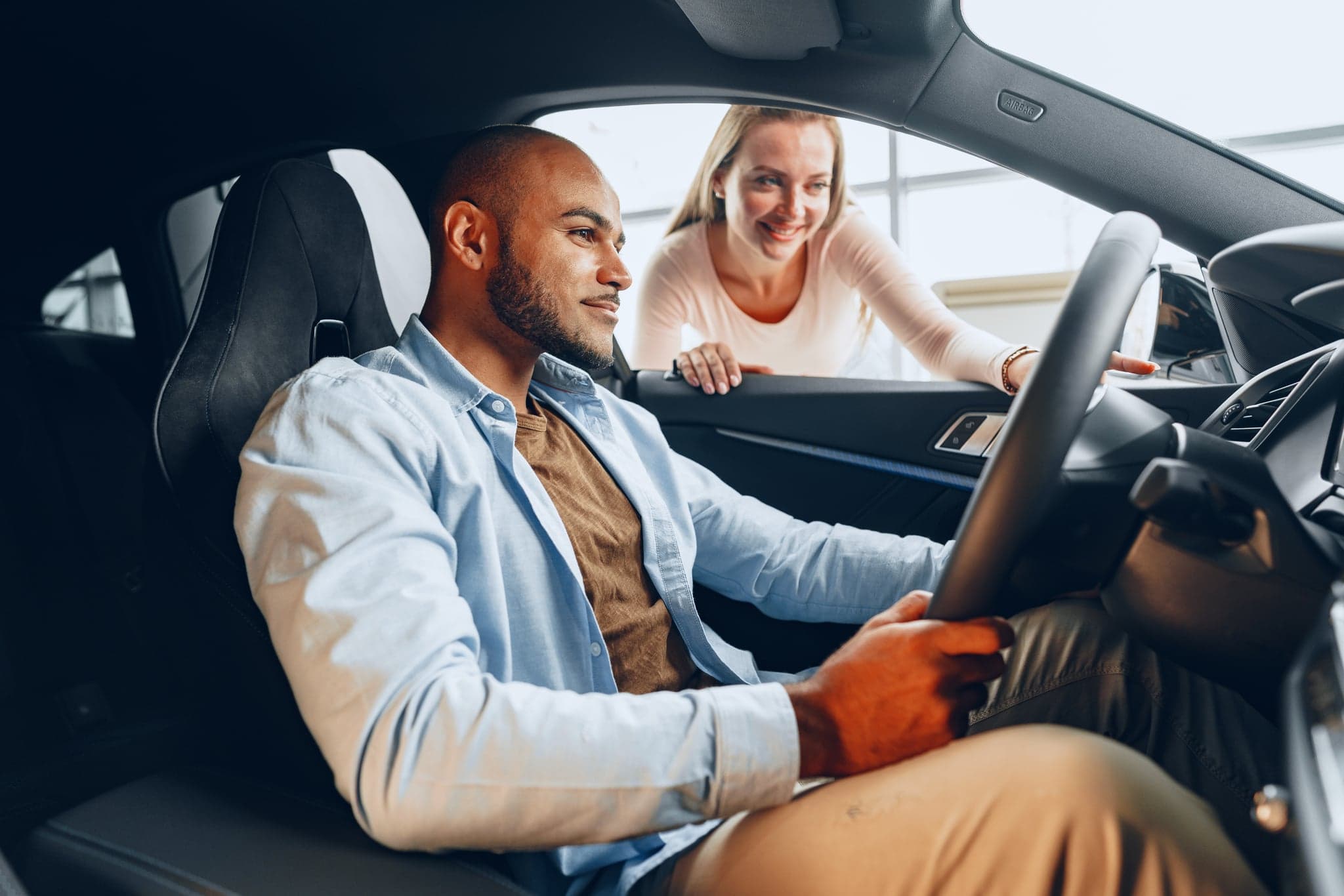 A couple happily inspecting a car they're buying through Axel